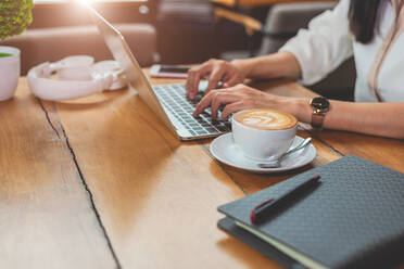 Cropped Bild der Geschäftsfrau mit Laptop im Restaurant Tabelle - EYF04018