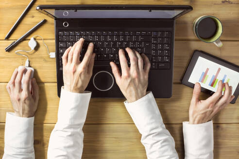 Cropped Hände des Mannes mit digitalen Tablet und Laptop im Büro - EYF04032