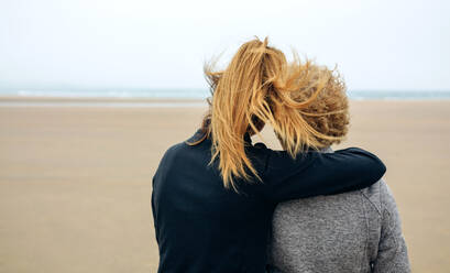 Rückansicht der Frau mit Mutter stehend am Strand gegen klaren Himmel - EYF04063