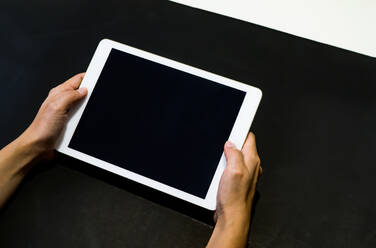 Abgeschnittene Hände mit digitalem Tablet auf dem Tisch - EYF04073