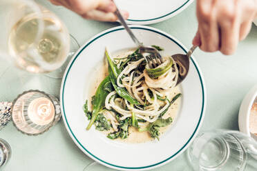 Cropped Hands Having Pasta On Table - EYF04083