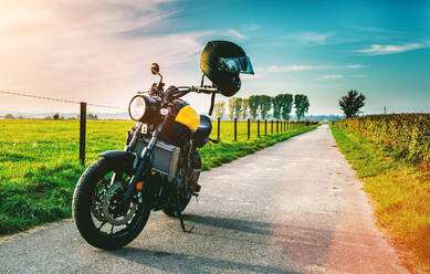 Motorrad geparkt auf der Straße von Grassy Feld gegen Himmel - EYF04121