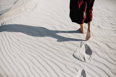 Low Section Of Woman Walking On Sand At Desert - EYF04163