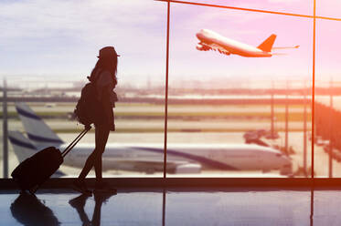 Junge Frau mit Gepäck am Flughafen - EYF04192