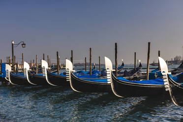 Italy, Venice, Row of moored gondolas at dusk - FMOF00956