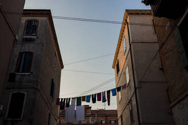 Italien, Venedig, Wäsche trocknet auf einer Wäscheleine zwischen zwei Häusern - FMOF00958