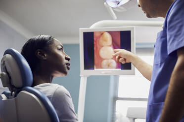 Zahnarzt zeigt dem Patienten in der Zahnarztpraxis ein Bild der Zähne - PWF00019