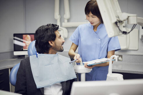 Medical secretary preparing dental treatment for patient - PWF00046