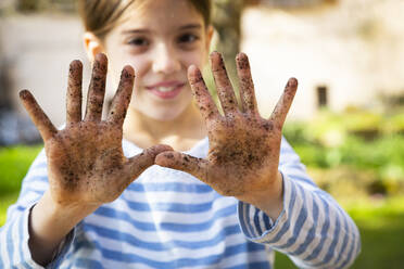 Porträt eines lächelnden Mädchens, das ihre schmutzigen Hände zeigt - LVF08794
