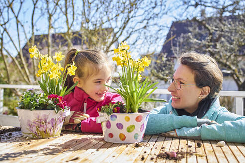 Mutter und Tochter pflanzen Blumen auf dem Balkon - DIKF00445