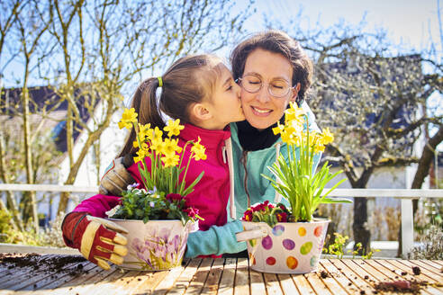 Mutter und Tochter pflanzen gemeinsam Blumen auf dem Balkon - DIKF00448