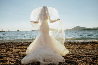 Bride Standing At Beach Against Sky - EYF04283