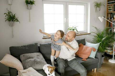 Vater und lachende Tochter spielen zu Hause, lizenzfreies Stockfoto