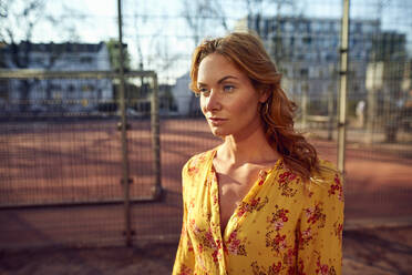 Portrait of red-haired woman at football ground - JHAF00097