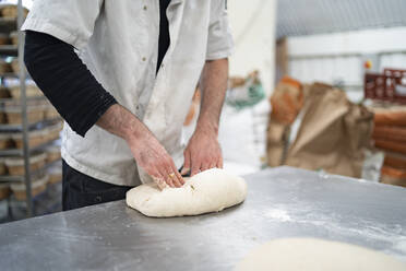 Nahaufnahme von Bäcker kleinen Laib Brot in Bäckerei - FBAF01477