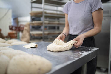 Close-up of woman preparing bread in bakery - FBAF01478