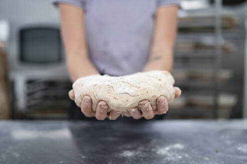 Nahaufnahme einer Frau bei der Zubereitung von Brot in einer Bäckerei - FBAF01481