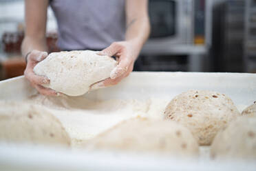 Nahaufnahme einer Frau bei der Zubereitung von Brot in einer Bäckerei - FBAF01483