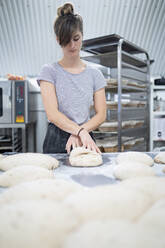 Frau bereitet Brot in einer Bäckerei zu - FBAF01487