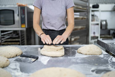 Nahaufnahme einer Frau bei der Zubereitung von Brot in einer Bäckerei - FBAF01489