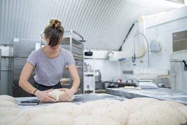 Frau bereitet Brot in einer Bäckerei zu - FBAF01490