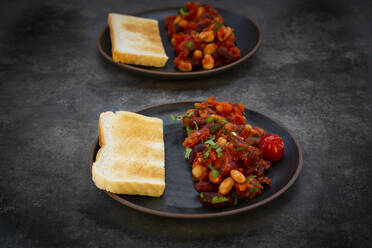 Two plates of baked beans with toasted bread - LVF08802