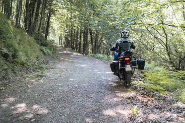 Motorradfahrer bei einer Fahrt auf einem Waldweg - FBAF01501