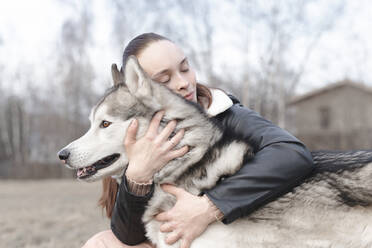 Glückliche Frau, die ihren Hund knuddelt - EYAF01027