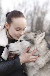 Porträt einer Frau, die ihren Husky streichelt - EYAF01037