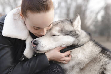 Woman cuddling her husky - EYAF01038