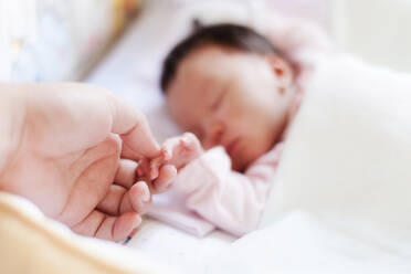 Nahaufnahme der Mutter, die die Hand des Babys hält - EYF04385