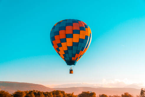 Low Angle View of Hot Air Ballon Flying In Mid-Air gegen klaren blauen Himmel - EYF04434