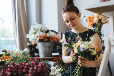 Woman Arranging Flowers In Shop - EYF04445