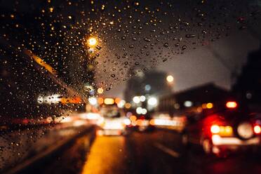 Nahaufnahme von Regentropfen auf Auto Windschutzscheibe bei Nacht - EYF04477