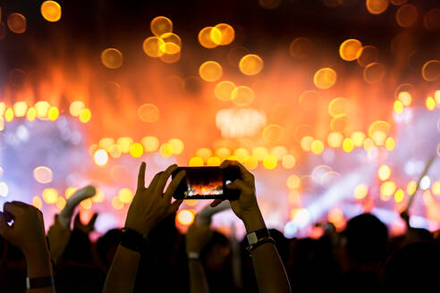 Cropped Hände der Person Fotografieren mit Smart Phone bei Musik-Konzert - EYF04525