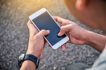 Close-Up Of Man Using Mobile Phone Outdoors - EYF04541