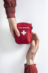 Overhead view of woman handing over first aid kit to man - MSUF00280