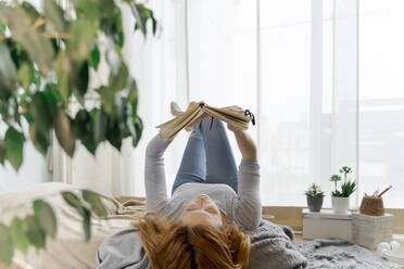 Young woman reading notebook at home - AFVF06016