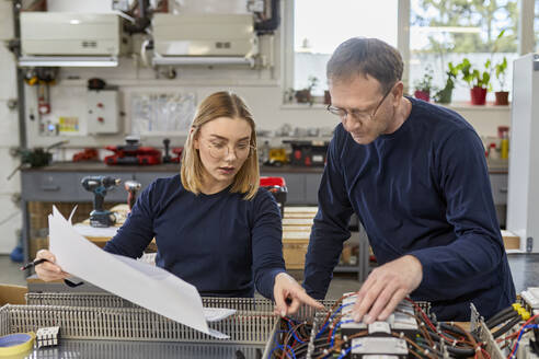 Zwei Elektriker arbeiten in der Werkstatt an Schaltkreisen - ZEDF03210