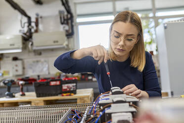 Elektrikerin bei der Arbeit an einem Schaltkreis in der Werkstatt - ZEDF03212