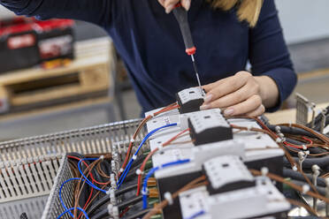 Nahaufnahme eines Elektrikers bei der Arbeit an einem Schaltkreis in einer Werkstatt - ZEDF03213