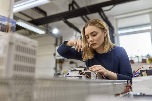 Elektrikerin bei der Arbeit an einem Schaltkreis in der Werkstatt - ZEDF03215