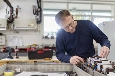 Elektriker bei Arbeiten an Schaltkreisen in der Werkstatt - ZEDF03217