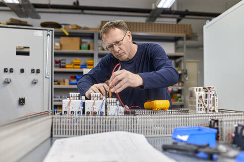 Elektriker bei Arbeiten an Schaltkreisen in der Werkstatt - ZEDF03228