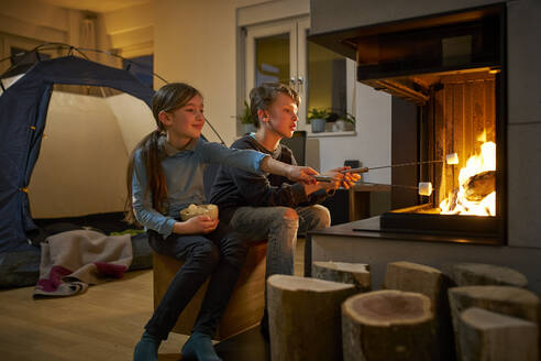 Bruder und Schwester beim Grillen und Zelten im Wohnzimmer - DIKF00455