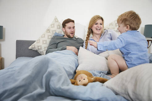 Familie beim Entspannen und Springen auf dem Bett - FSF01016