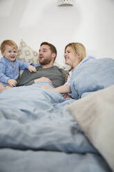 Family relaxing together on bed - FSF01019