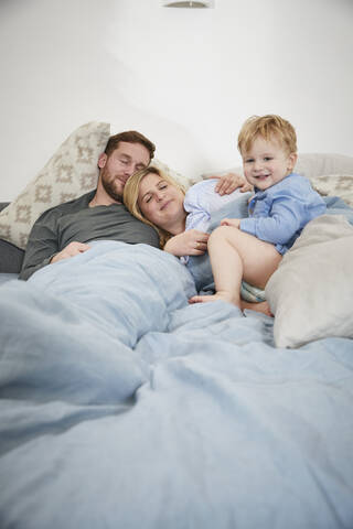 Family in the morning lying in bed stock photo