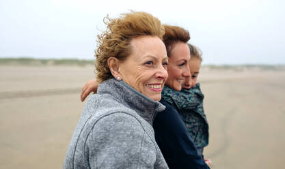 Frauen und Mädchen gehen am Strand spazieren - EYF04592