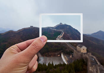 Close-Up Of Hand Holding Photograph Against Mountain - EYF04689